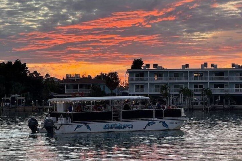 A boat with passengers on a body of water during sunset. 4