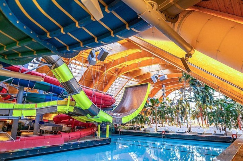 An indoor water park with multiple slides and a pool. 5