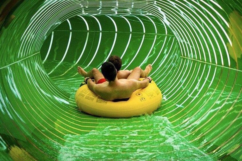 A person sliding down a water slide in a tube. 3