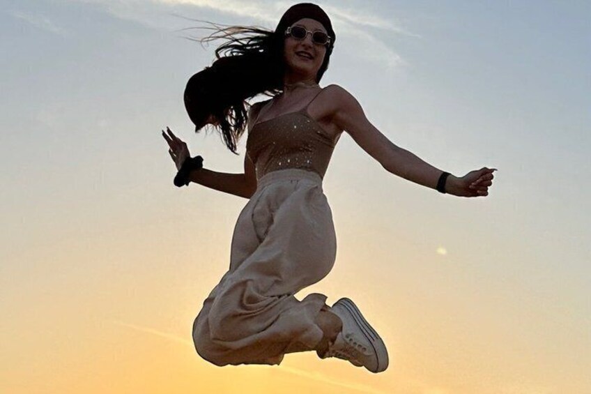 A person jumping in the air against a sunset sky. 3