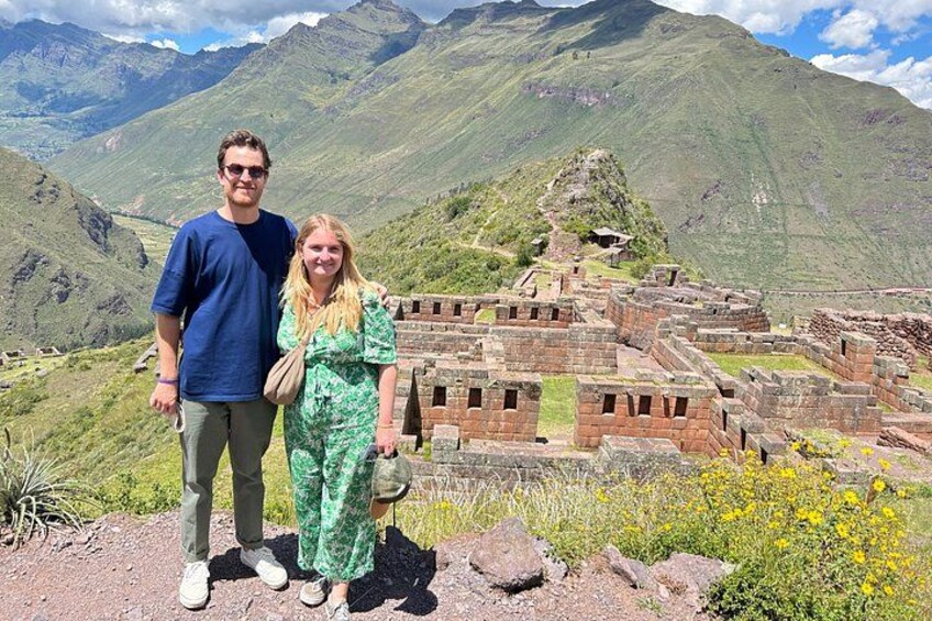 A couple standing in front of ancient ruins with mountains in the background. 2