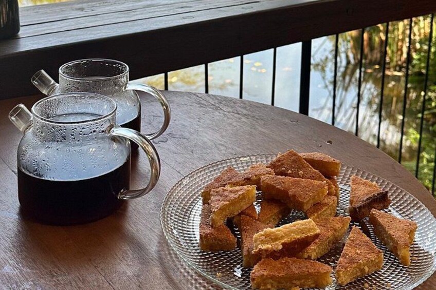 A wooden table with a glass mug and a plate of fried food. 3