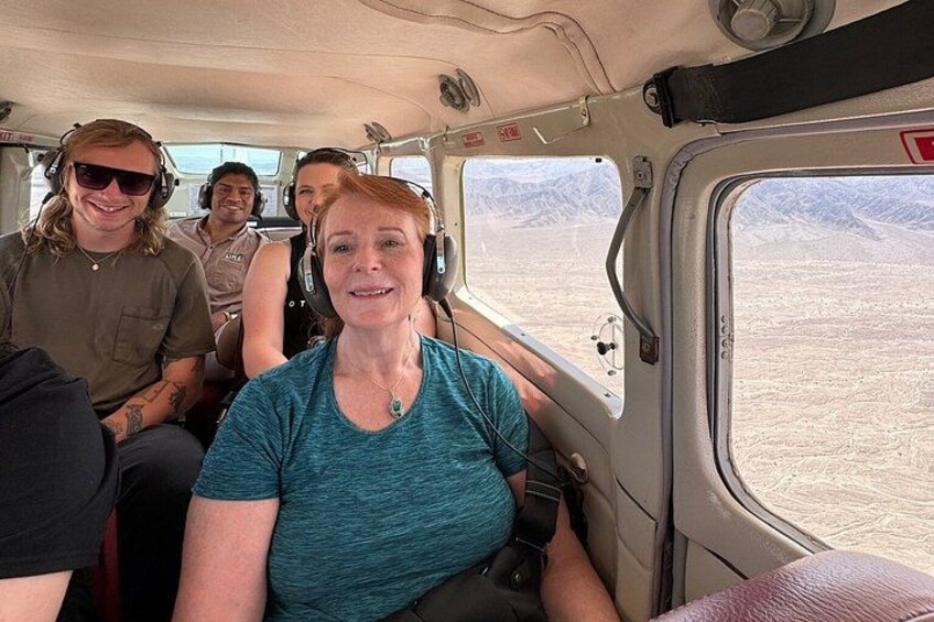 Un groupe de personnes se trouve à l’intérieur d’un véhicule, et on peut apercevoir un paysage désertique à travers la fenêtre. 3