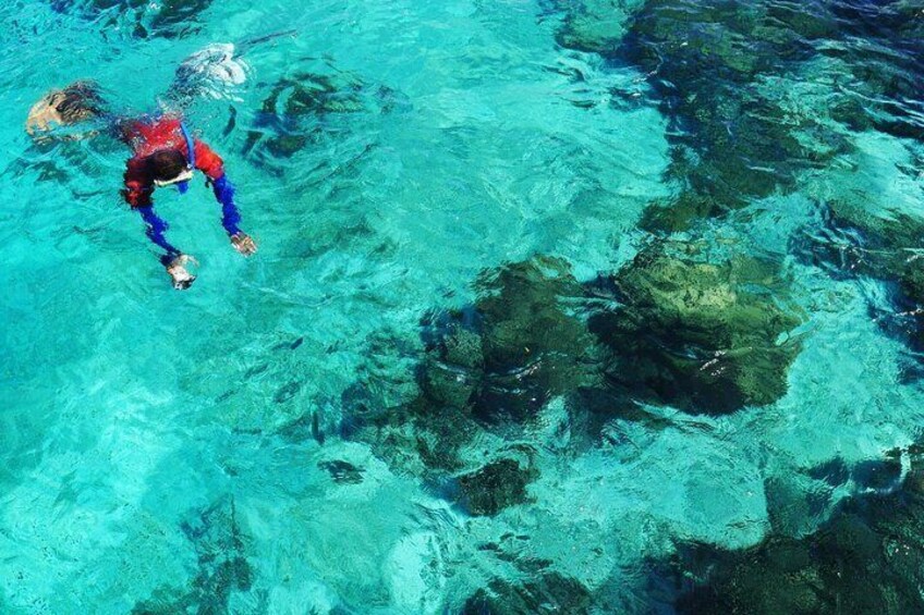 A person snorkeling in clear blue water. 5