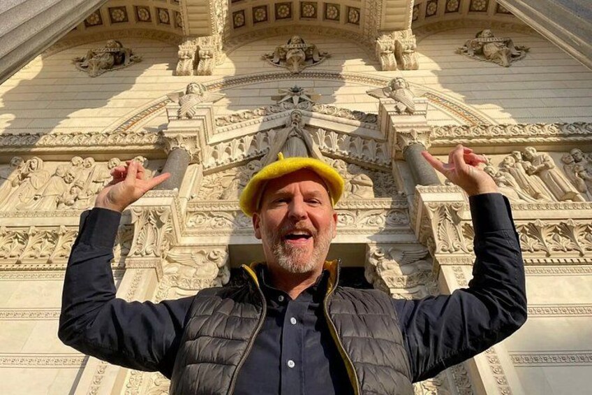 Une personne se tient devant une structure architecturale complexe, ornée de sculptures et de motifs décoratifs. 2