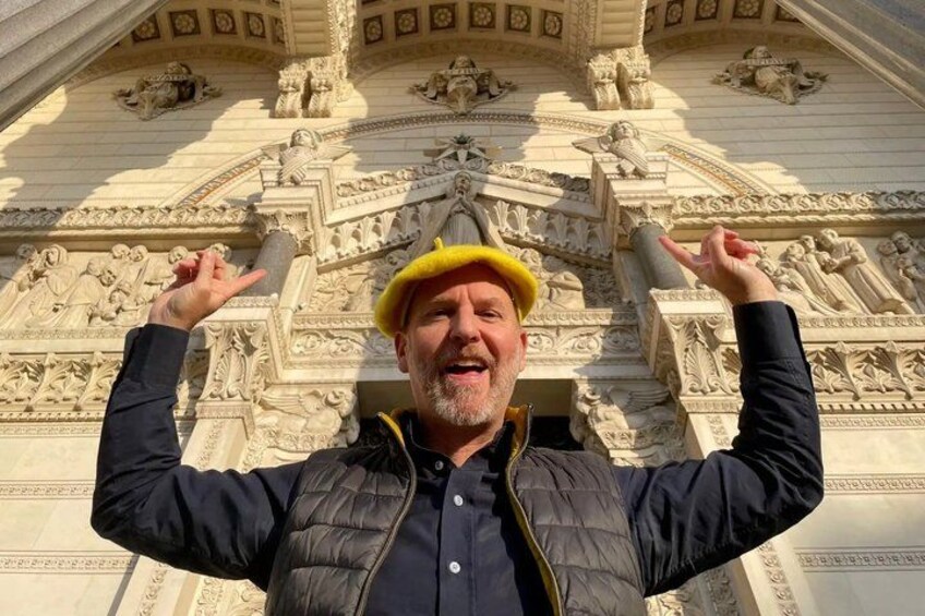 A person in front of a detailed architectural structure with ornate carvings and columns. 2