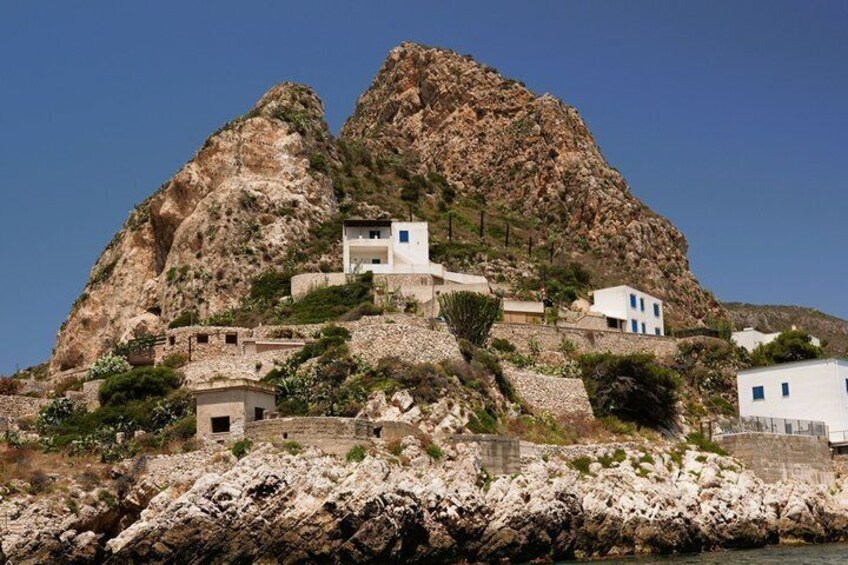 A rocky coastal village with white buildings perched on the cliffs. 5