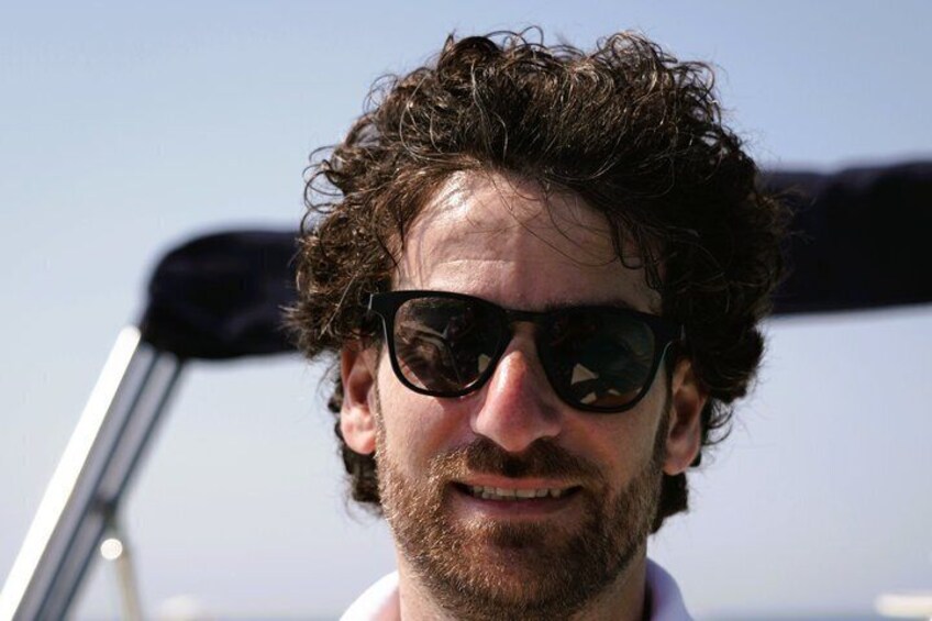 A person with curly hair and sunglasses on a boat. 3