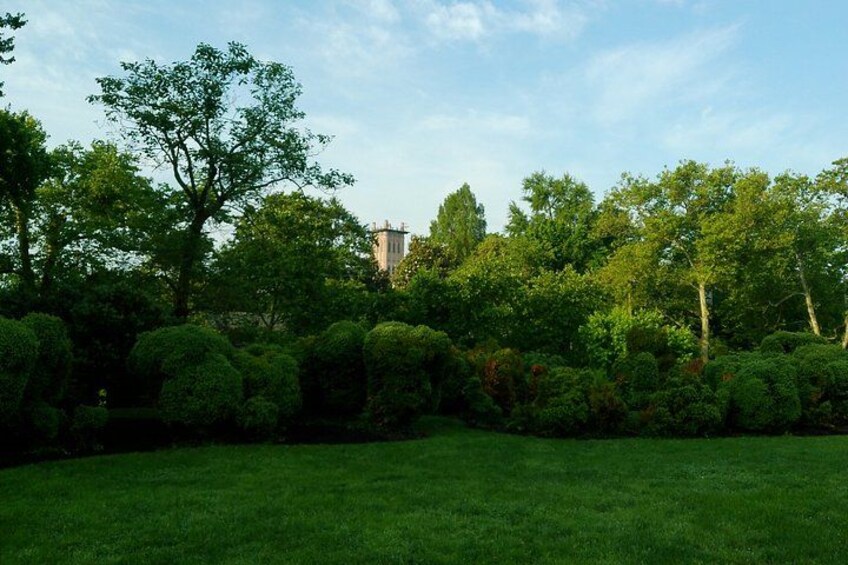 A lush green park with neatly trimmed bushes and trees. 2