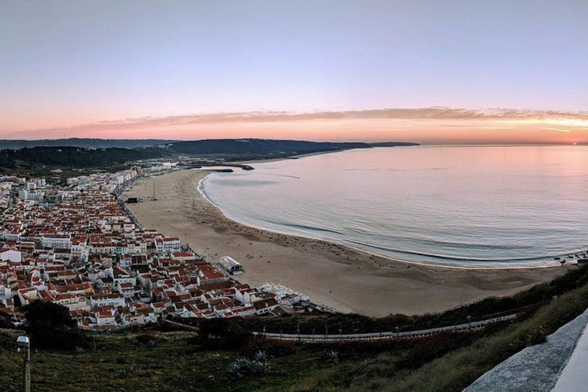A coastal town with a beach, houses, and a sunset. 4