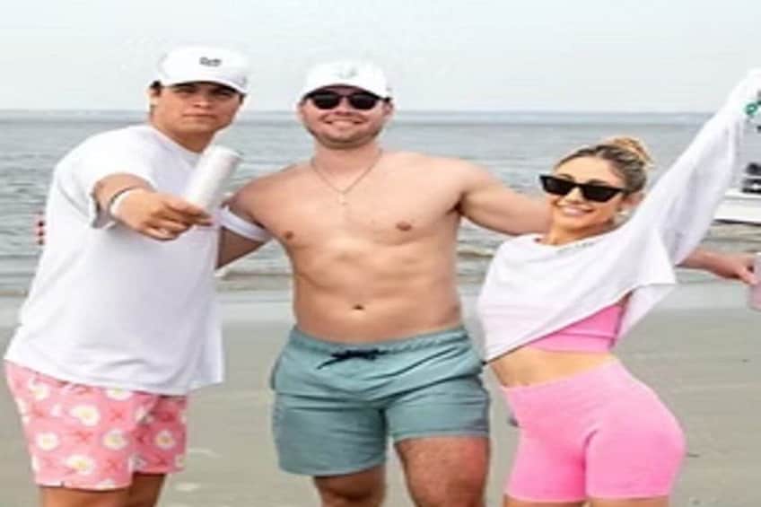 Drie mensen op een strand, met de oceaan op de achtergrond. 4