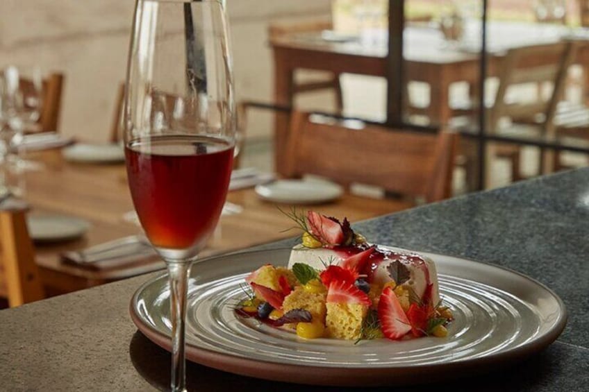 A dessert on a plate with a glass of red wine. 5