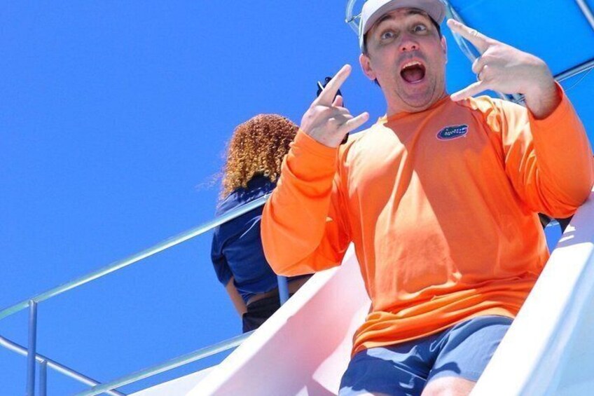 A person in an orange shirt sliding down a water slide. 4