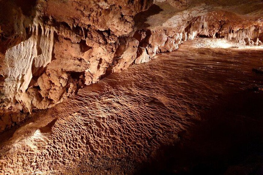 L’intérieur d’une grotte, avec des stalactites et un sol aux motifs variés. 2