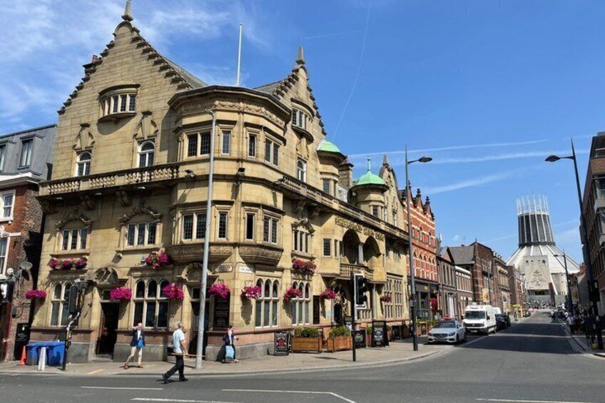 A historic building with ornate architecture, a street with cars, and a clear sky. 5