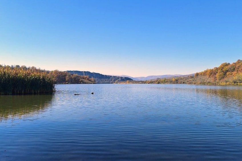 A calm lake surrounded by hills and trees. 3