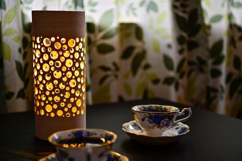 A decorative lantern, a teacup, and a saucer on a table. 1