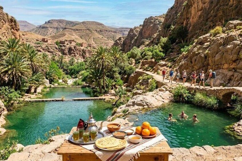 A group of people hiking in a mountainous area with a clear water body and palm trees. 5