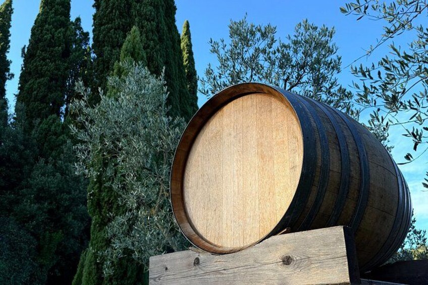 A wooden barrel on a wooden platform with trees and a clear sky in the background. 4