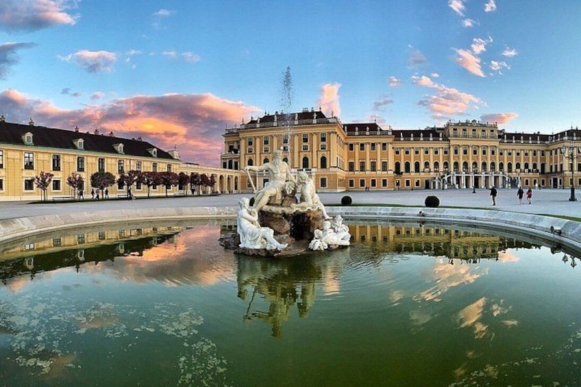 A historic building with a fountain in the foreground. 2
