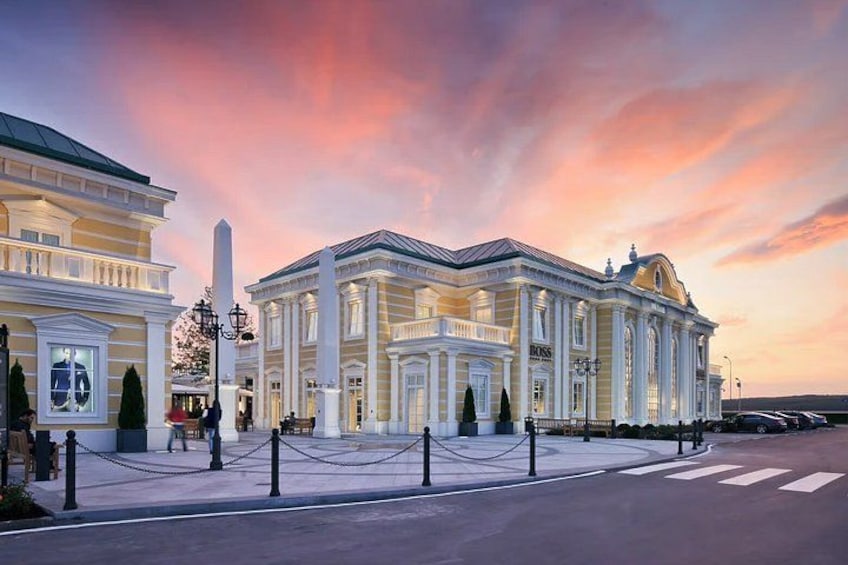 A grand building with classical architecture, a prominent obelisk, and a chain barrier in front. 5