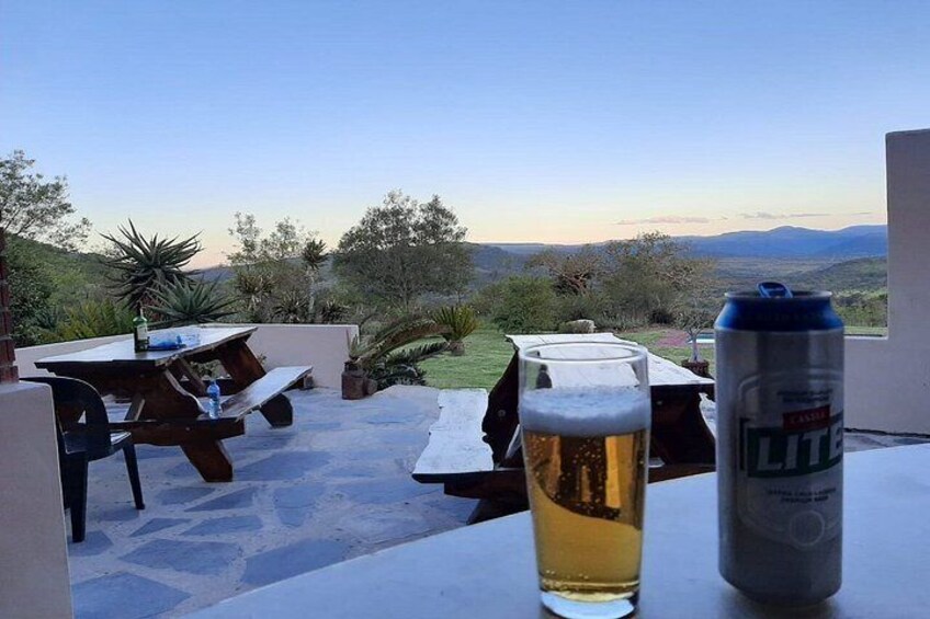 A patio with a table, a beer glass, and a can of beer. 4