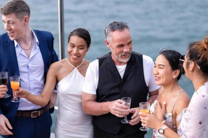 A group of people on a boat, holding drinks. 5