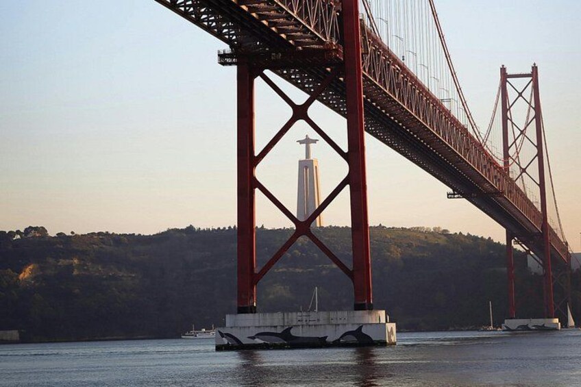 A large red bridge spanning a body of water with a white tower in the background. 3