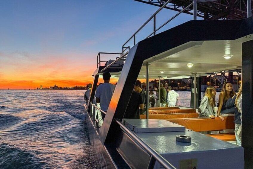 A boat with people on deck during sunset. 5