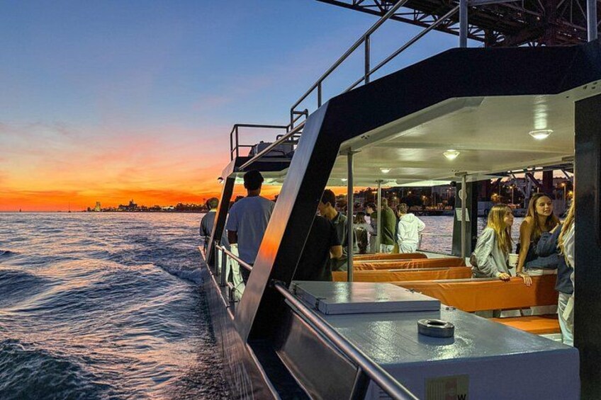 A boat with people on deck during sunset. 3