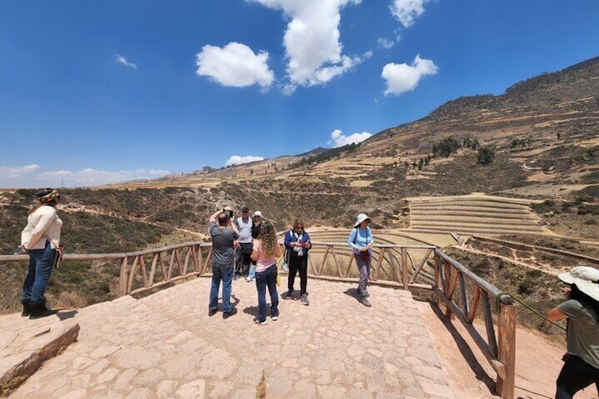 A group of people standing on a stone platform overlooking terraced fields. 5