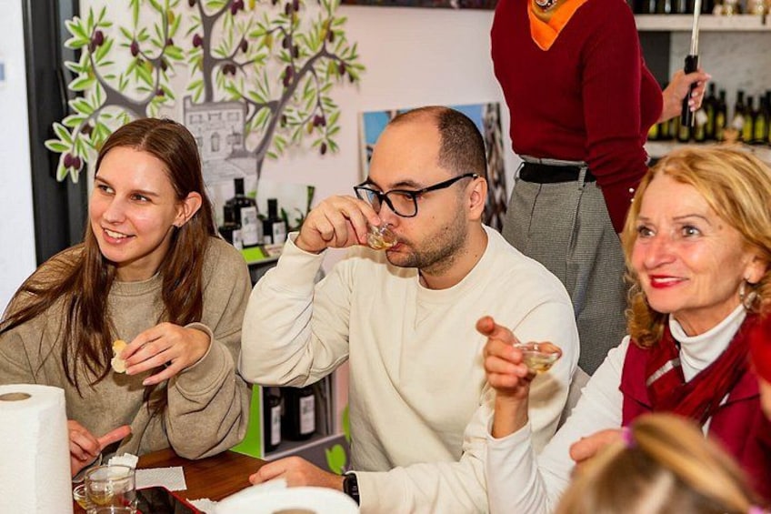 A group of people at a table with a bottle of wine, a glass, and a menu. 1