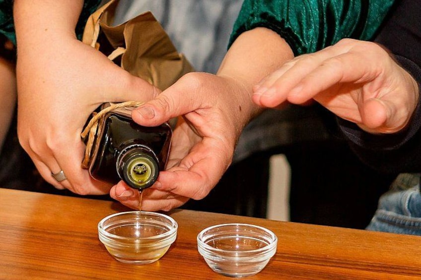 A person pouring a liquid from a bottle into two clear glass bowls. 3
