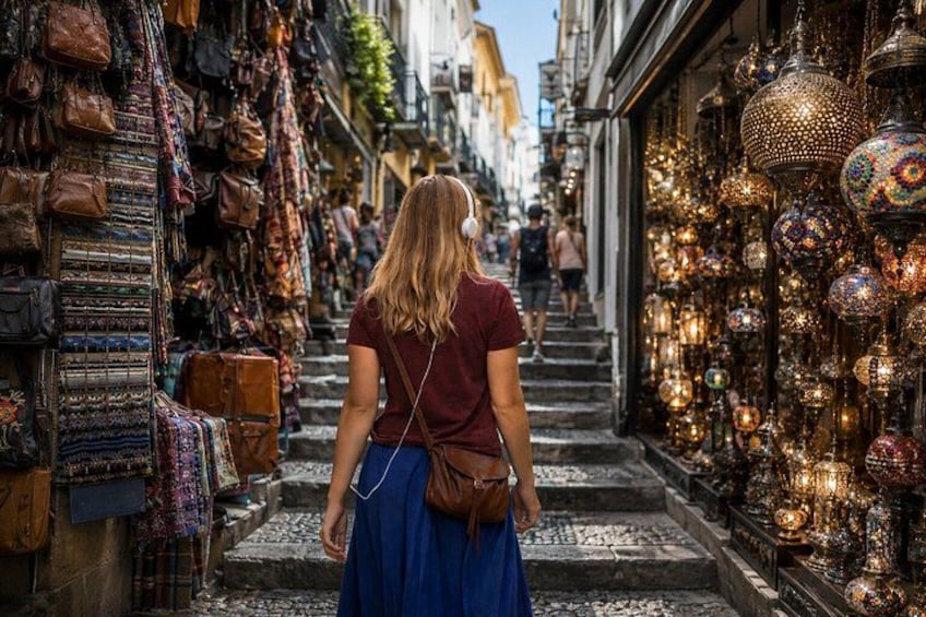 Una stretta via fiancheggiata da negozi che espongono borse e luci decorative. 1
