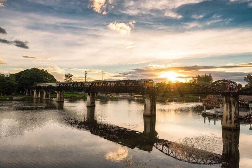 A bridge over a calm river with the sun setting in the background. 3