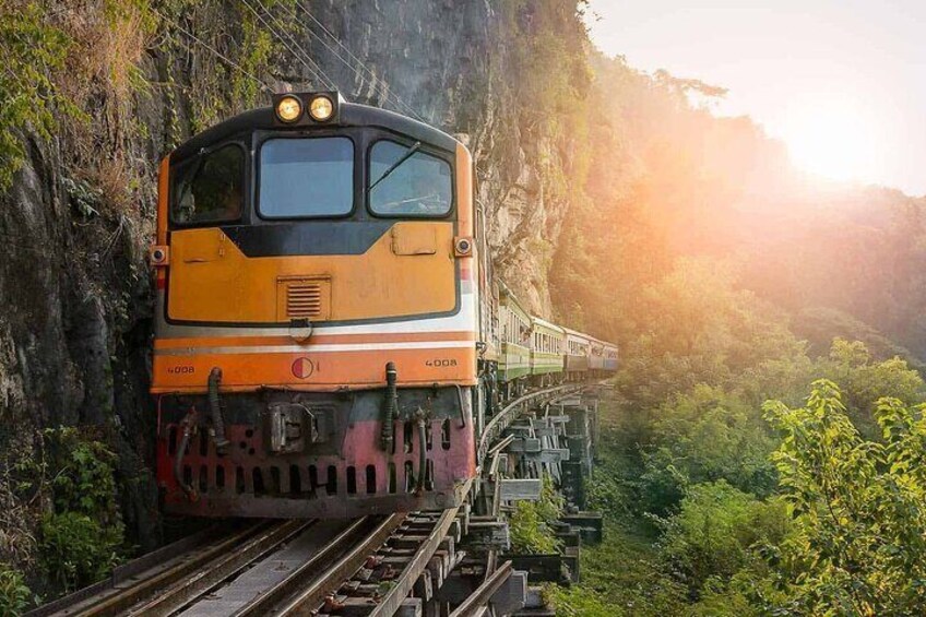 A train on a mountain track surrounded by greenery. 1