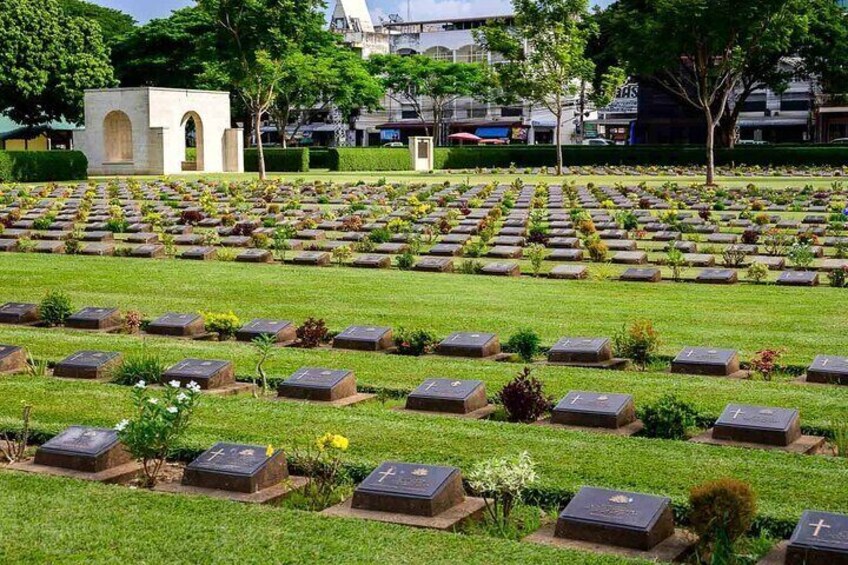 A cemetery with rows of graves, a central monument, and surrounding greenery. 5