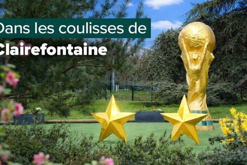 A golden statue in a park with yellow stars in the foreground. 2