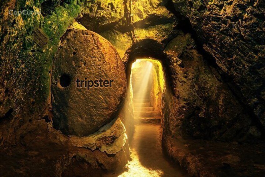 A cave with a narrow passageway and a large rock with a hole. 2