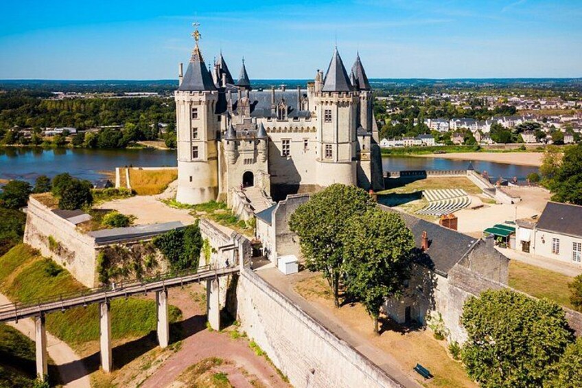 A castle with multiple towers, a river, and a bridge. 3