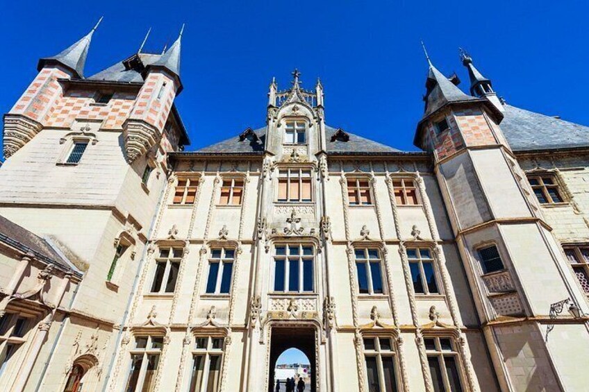 A historic building with ornate architecture, including a central tower and two smaller towers with spires. 2