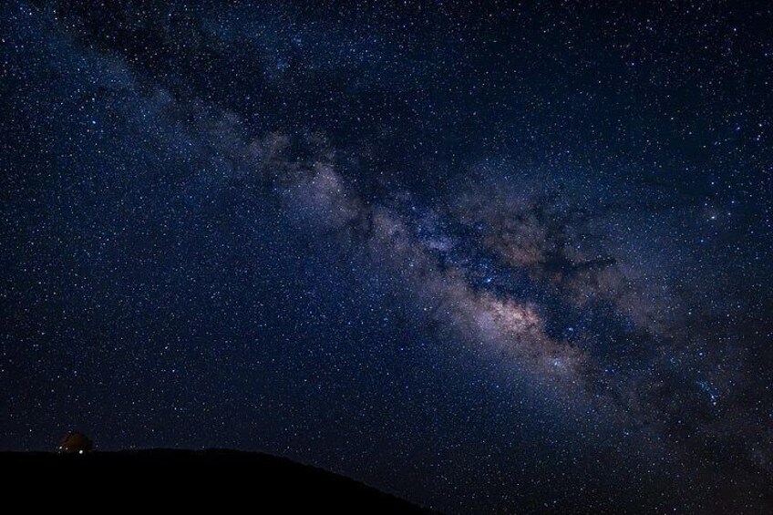 A starry night sky with the Milky Way and a silhouette of a hill. 5