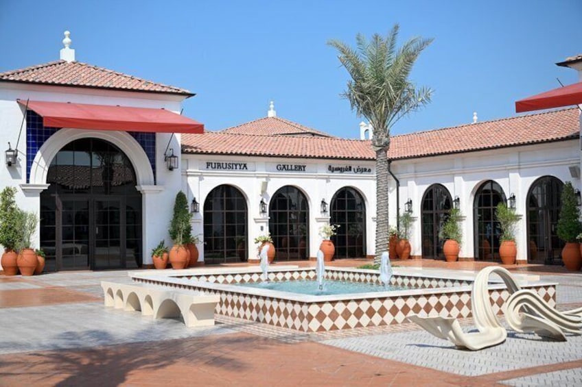 A building with a tiled roof, arched windows, and a fountain in the courtyard. 5