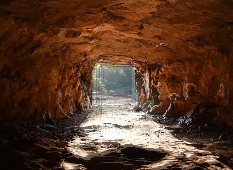 L'entrée d'une grotte, avec un passage étroit qui mène à une zone plus éclairée. 1