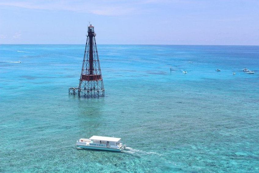 Un faro, aguas turquesas cristalinas y un barco. 2