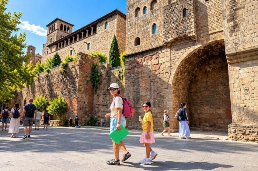 Un edificio histórico de piedra con arcos y turistas caminando frente a él. 2