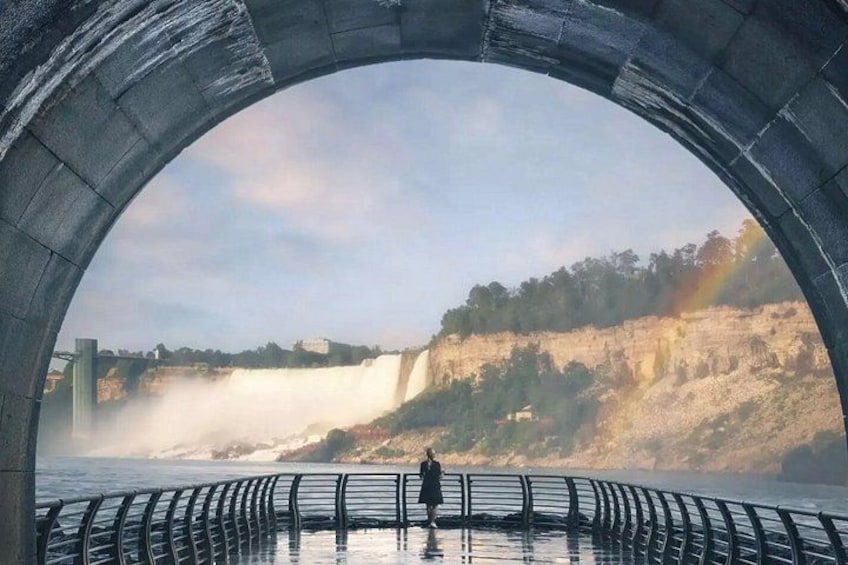 A person standing in a circular viewing platform overlooking a waterfall and a cliff. 5