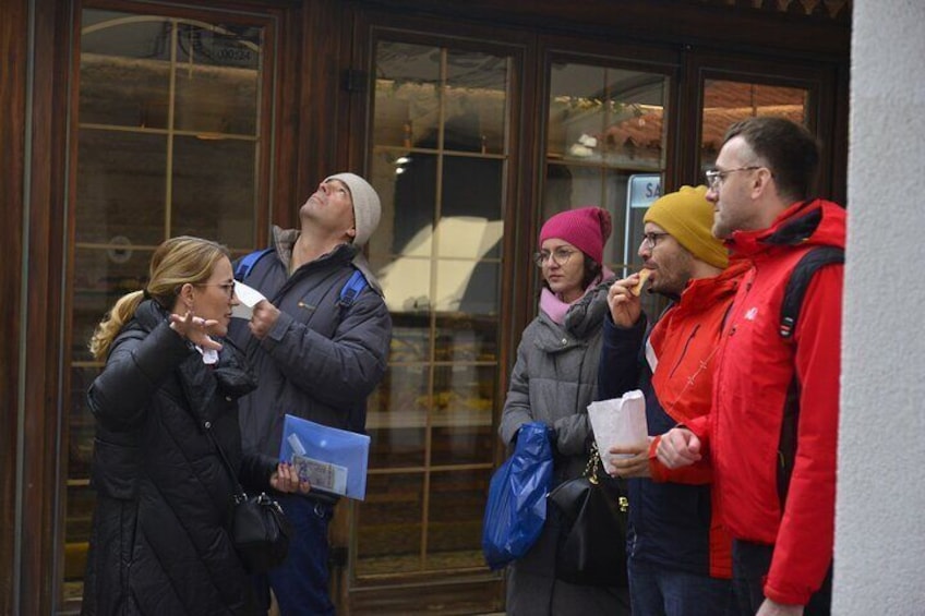 People standing outside a building, some holding papers and bags. 4