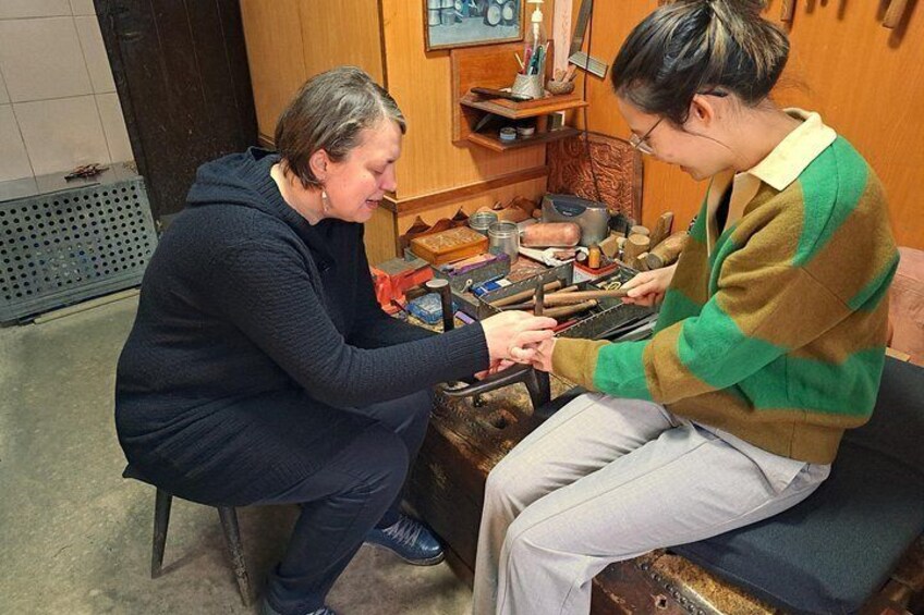Two people engaged in a craft activity, surrounded by tools and materials. 5