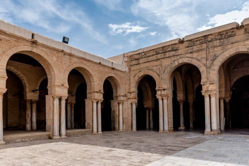 A courtyard with arches and columns. 4